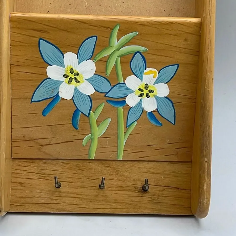 Vintage wooden wall organizer for keys and mail.